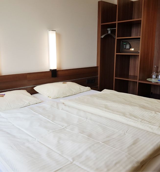 Bett in einem Hotelzimmer mit einem Regal im Hintergrund